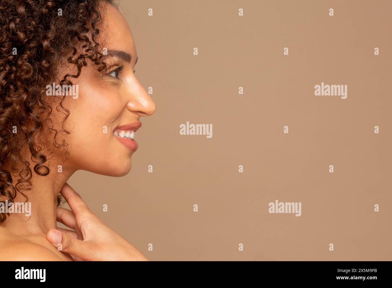 Profil von lächelnde Frau mit lockigem Haar Stockfoto