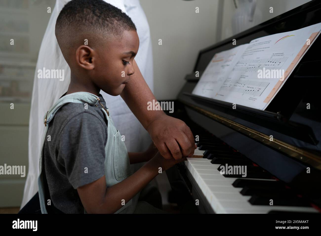 Mutter und Sohn (4-5) spielen Klavier Stockfoto
