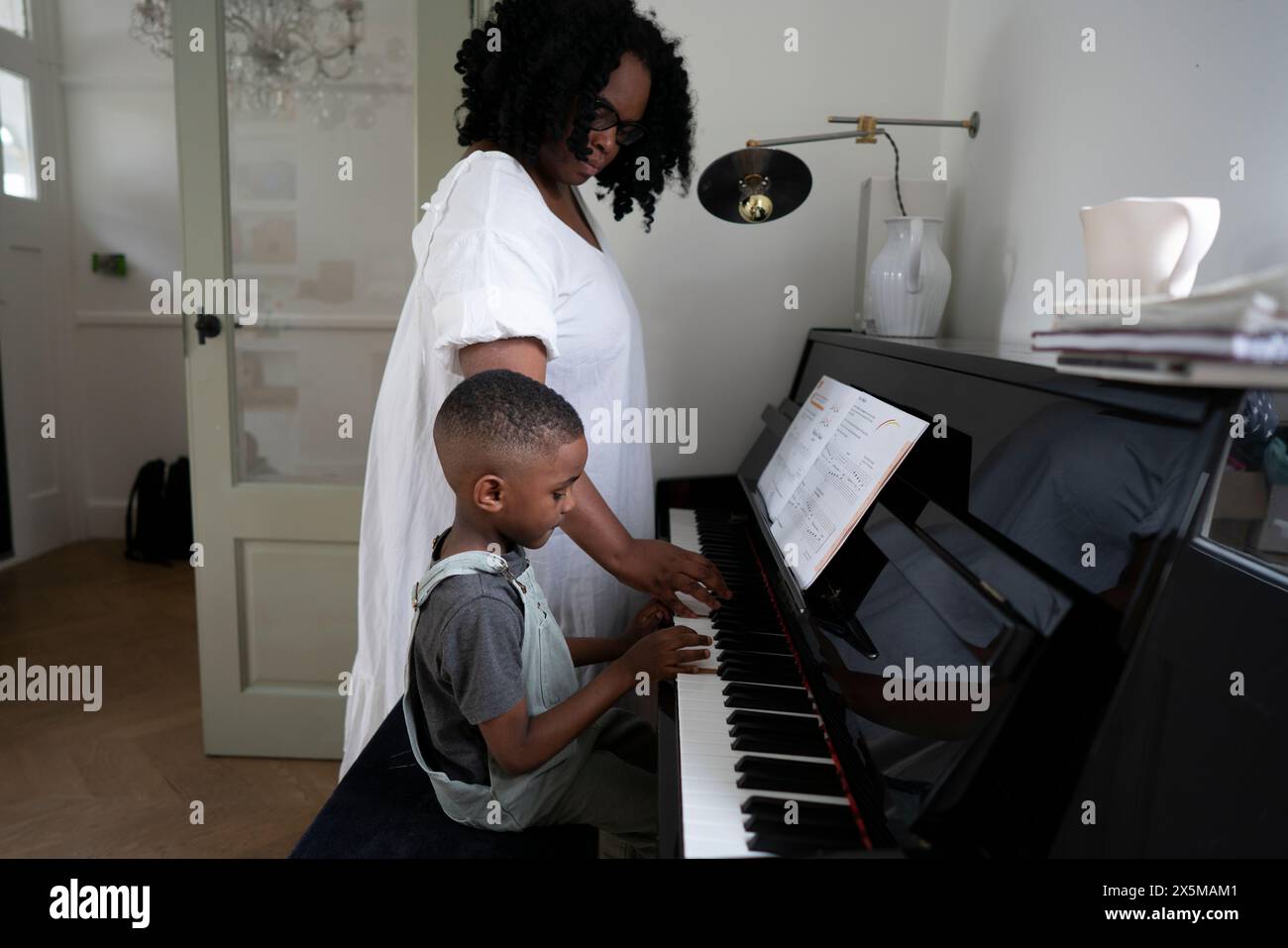 Mutter und Sohn (4-5) spielen Klavier Stockfoto
