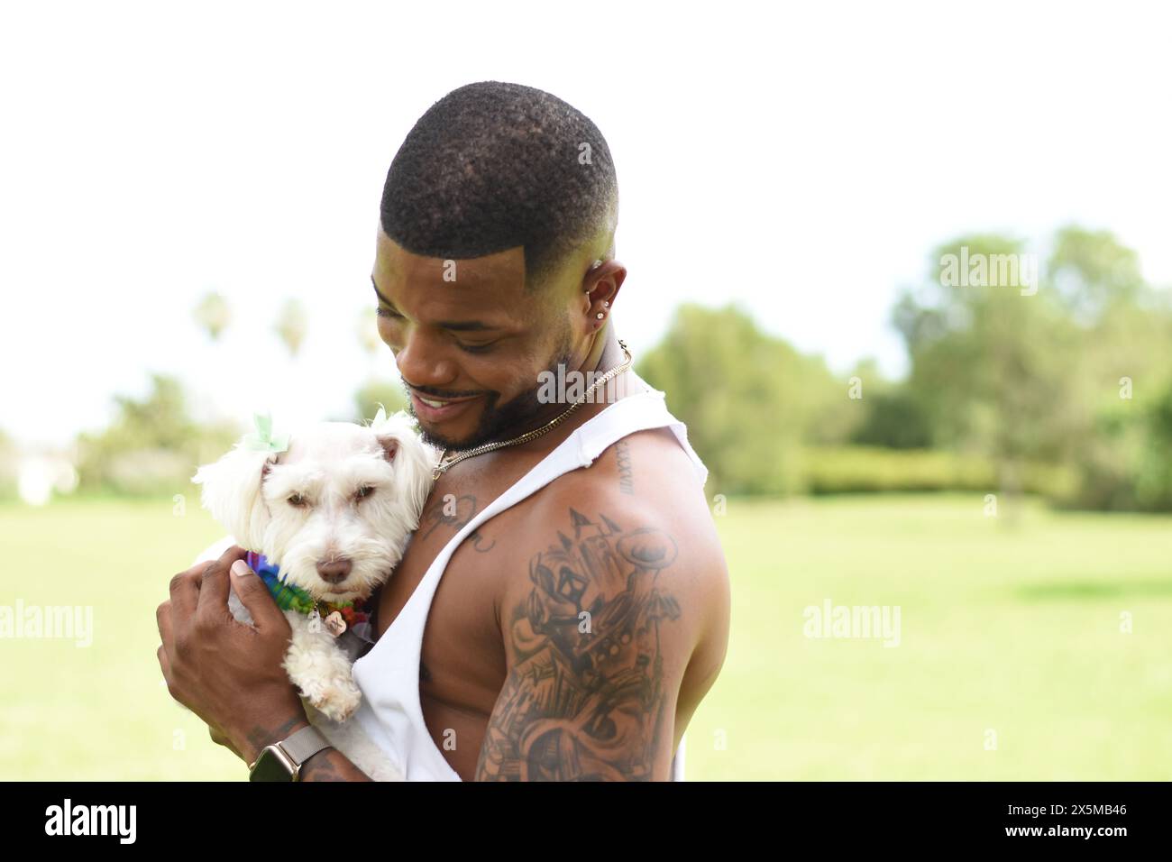 USA, Louisiana, lächelnder Mann, der einen kleinen weißen Hund im Park hält Stockfoto