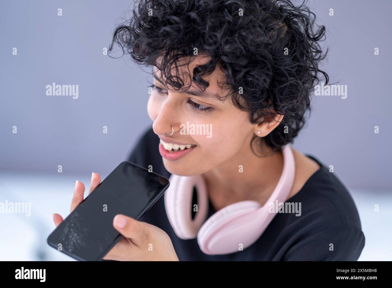 Junge Frau, die Sprachnachrichten am Telefon aufnimmt Stockfoto