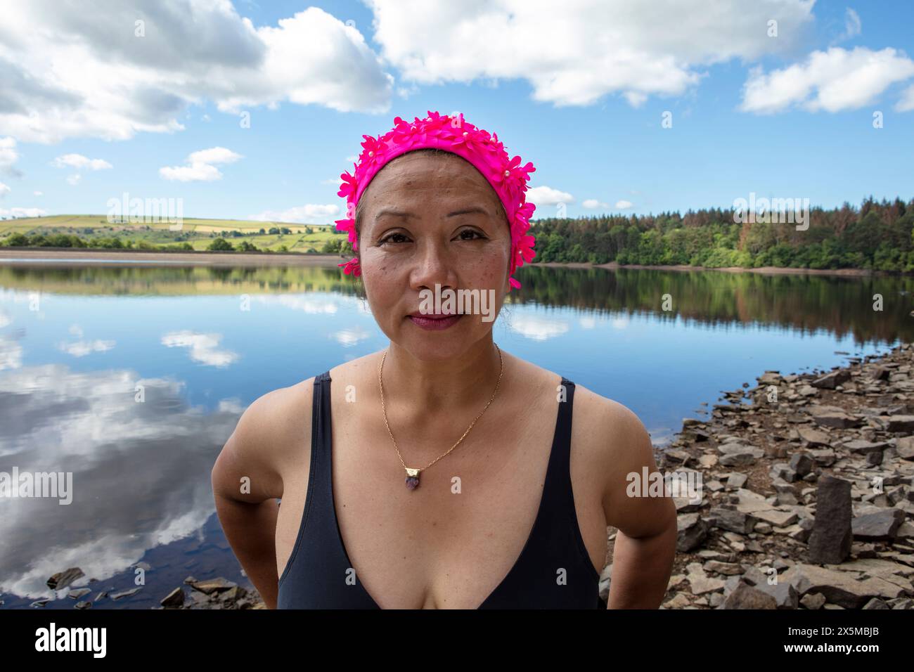 Porträt einer Frau in rosa Badekappe und Badeanzug am Seeufer, Yorkshire, Großbritannien Stockfoto