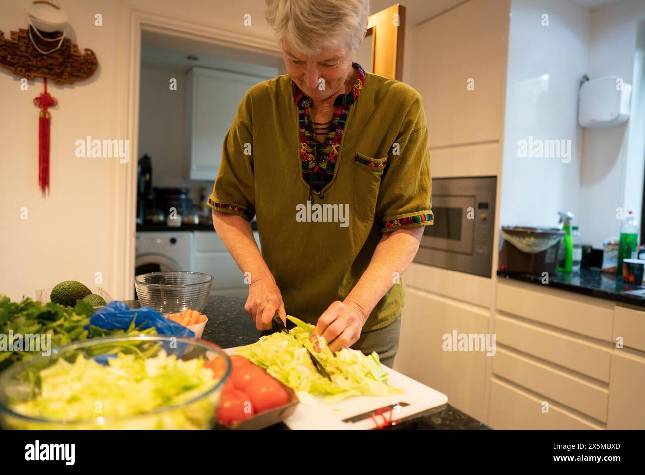 Ältere Frau Salat in der Küche vorbereiten Stockfoto