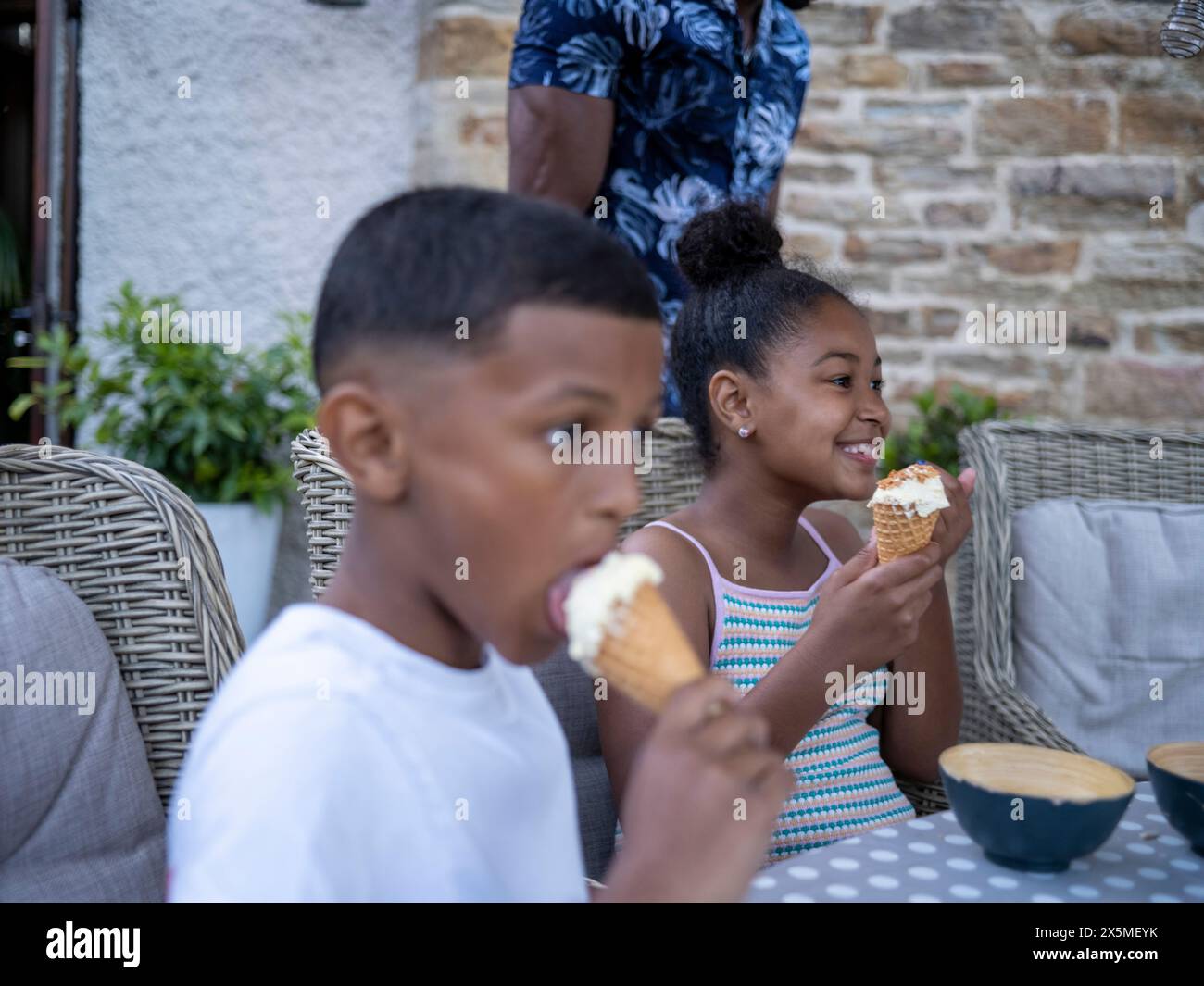 Geschwister (8-9, 10-11) essen Eis Stockfoto