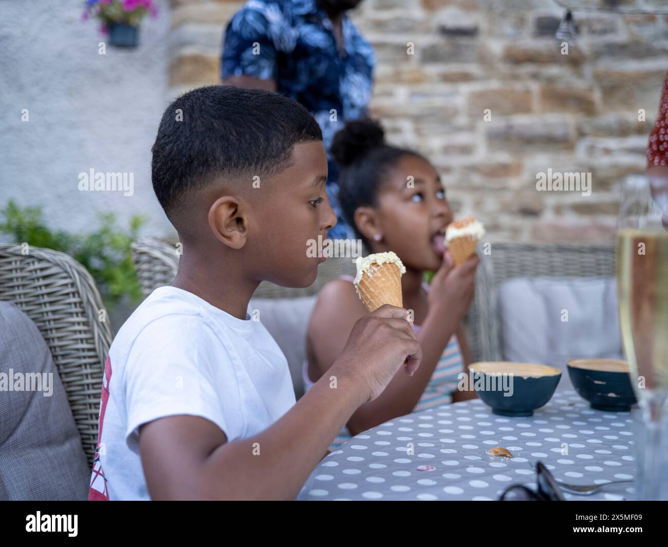 Geschwister (8-9, 10-11) essen Eis Stockfoto
