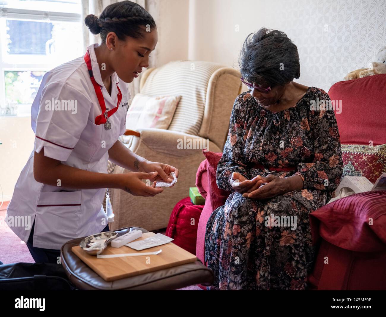 Krankenschwester, die sich um ältere Frauen kümmert, Medikamente verabreichen Stockfoto