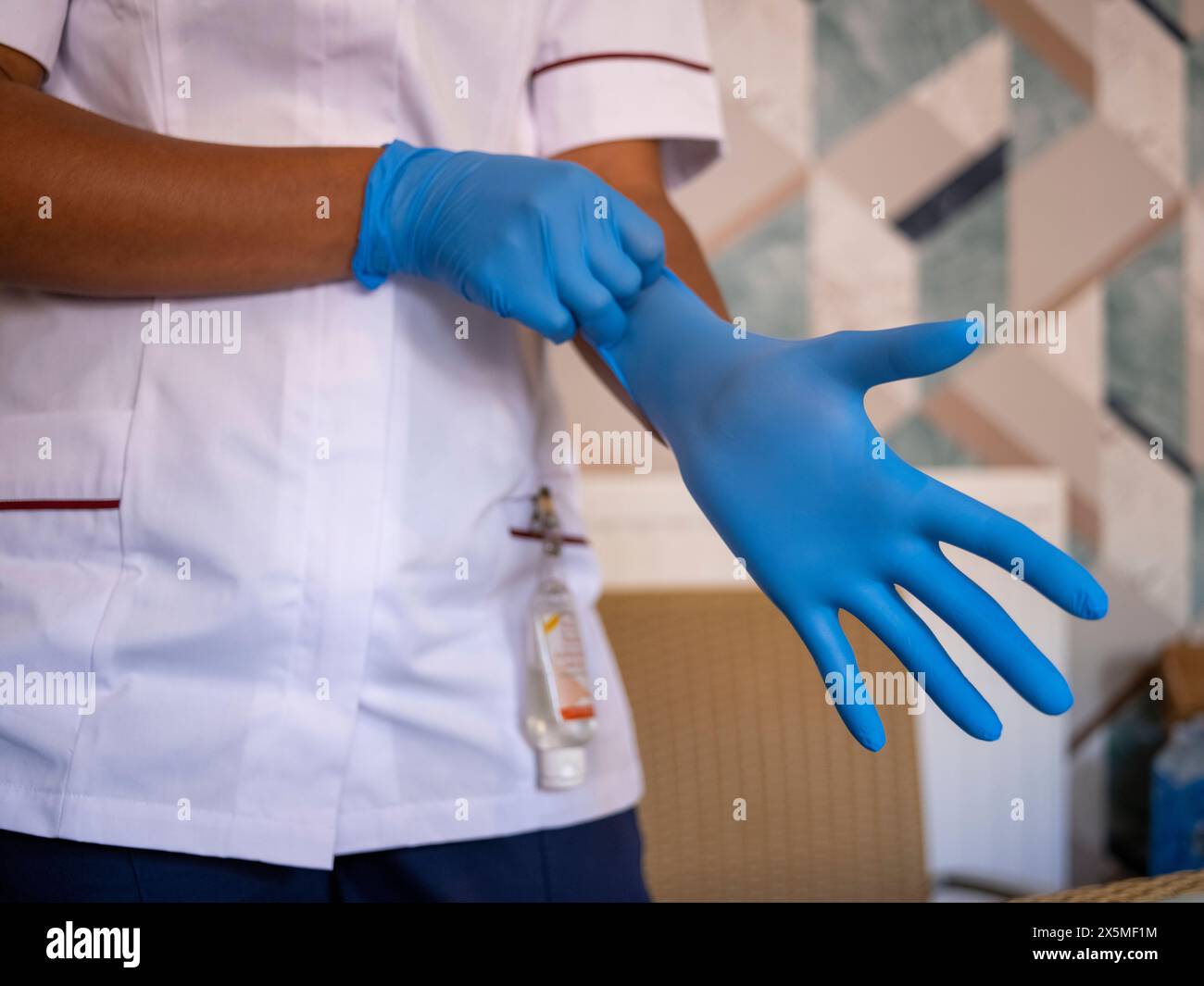 Mittelteil von Pflegefachleuten, die chirurgische Handschuhe einstellen Stockfoto