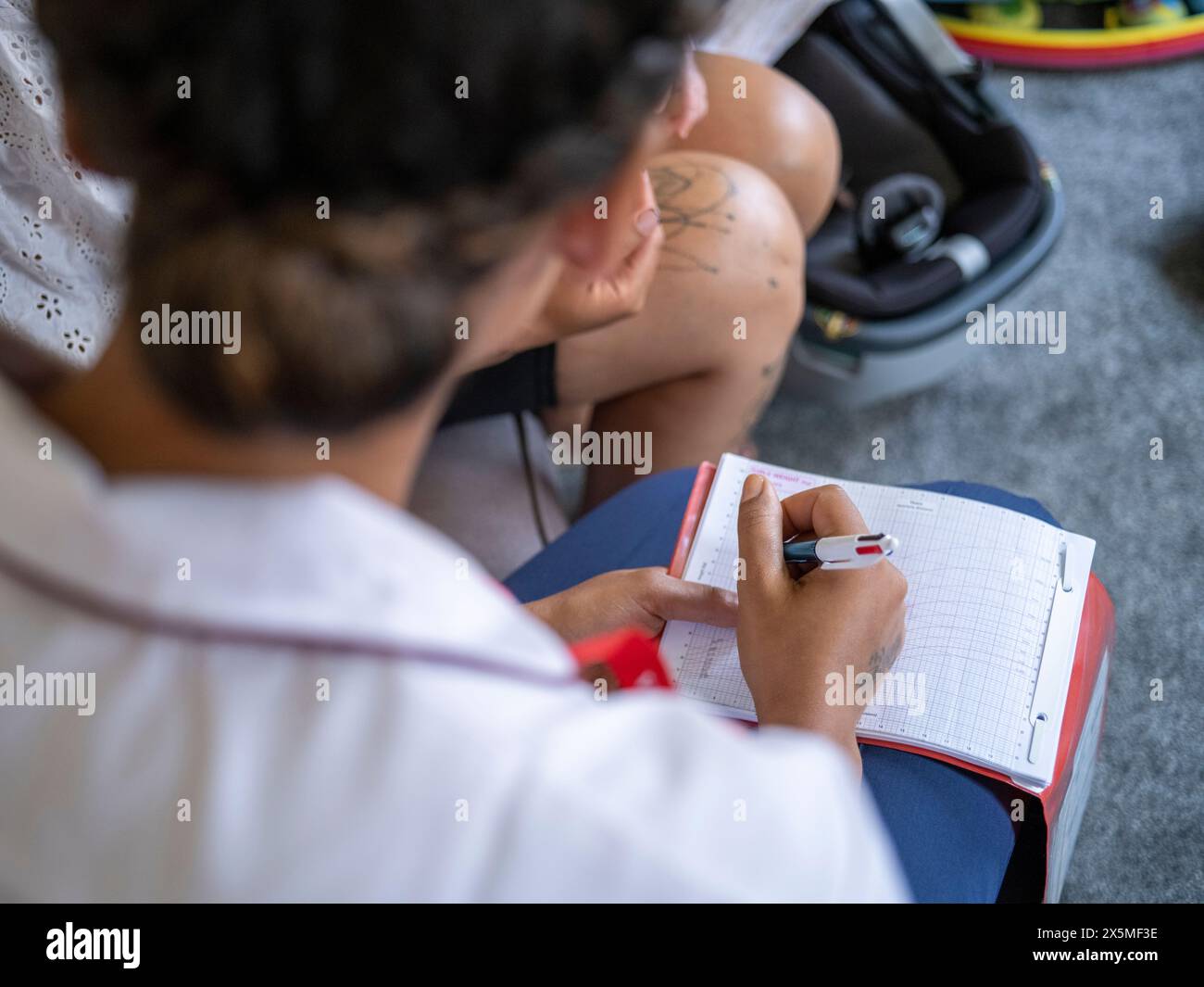 Krankenschwester schreibt medizinische Daten über die Schulter Stockfoto