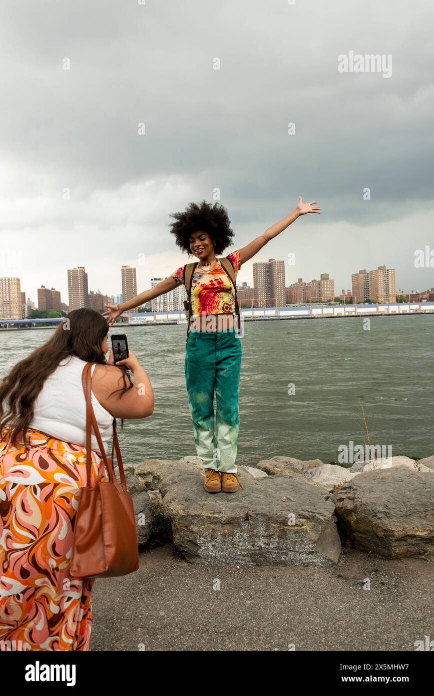 USA, New York City, zwei Frauen, die Fotos am Fluss machen Stockfoto