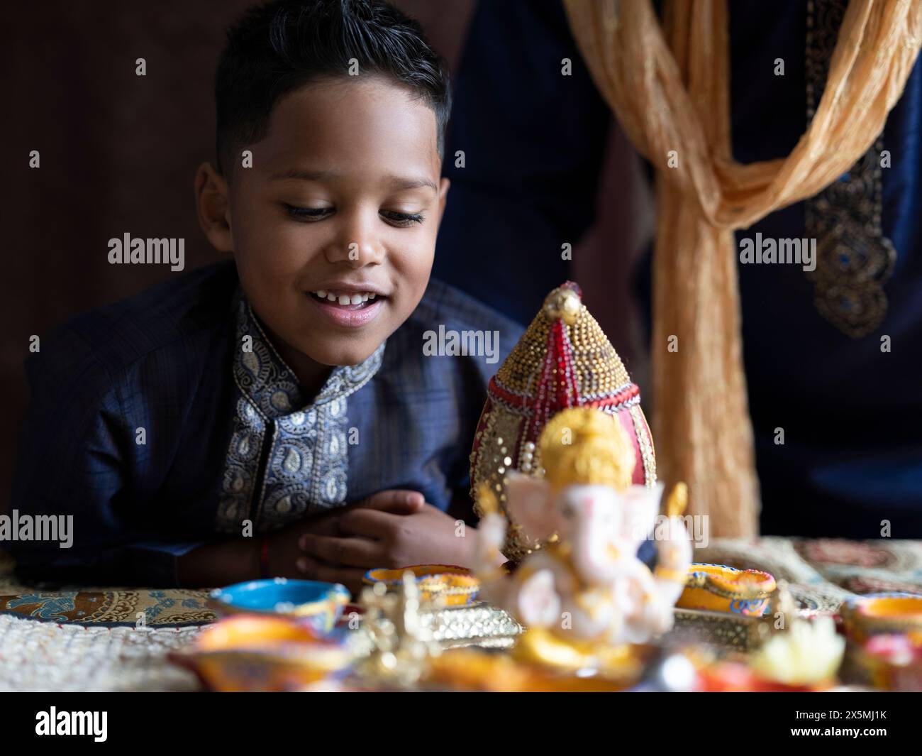 Junge, der sich Diya ansieht, die für die Diwali-Feier vorgesehen ist Stockfoto