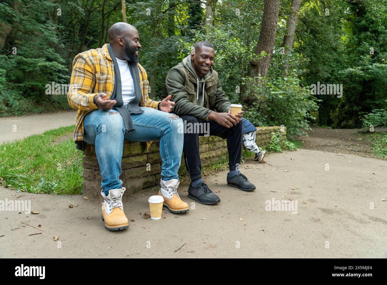Zwei lächelnde Männer reden im Park Stockfoto