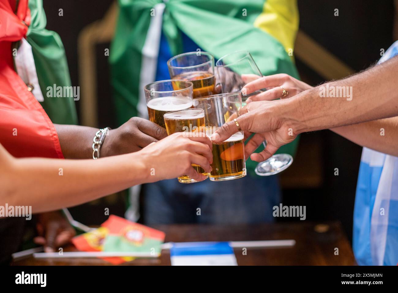 Freunde, die in Nationalflaggen gekleidet sind, um beim WM-Wettbewerb Bier zu trinken Stockfoto