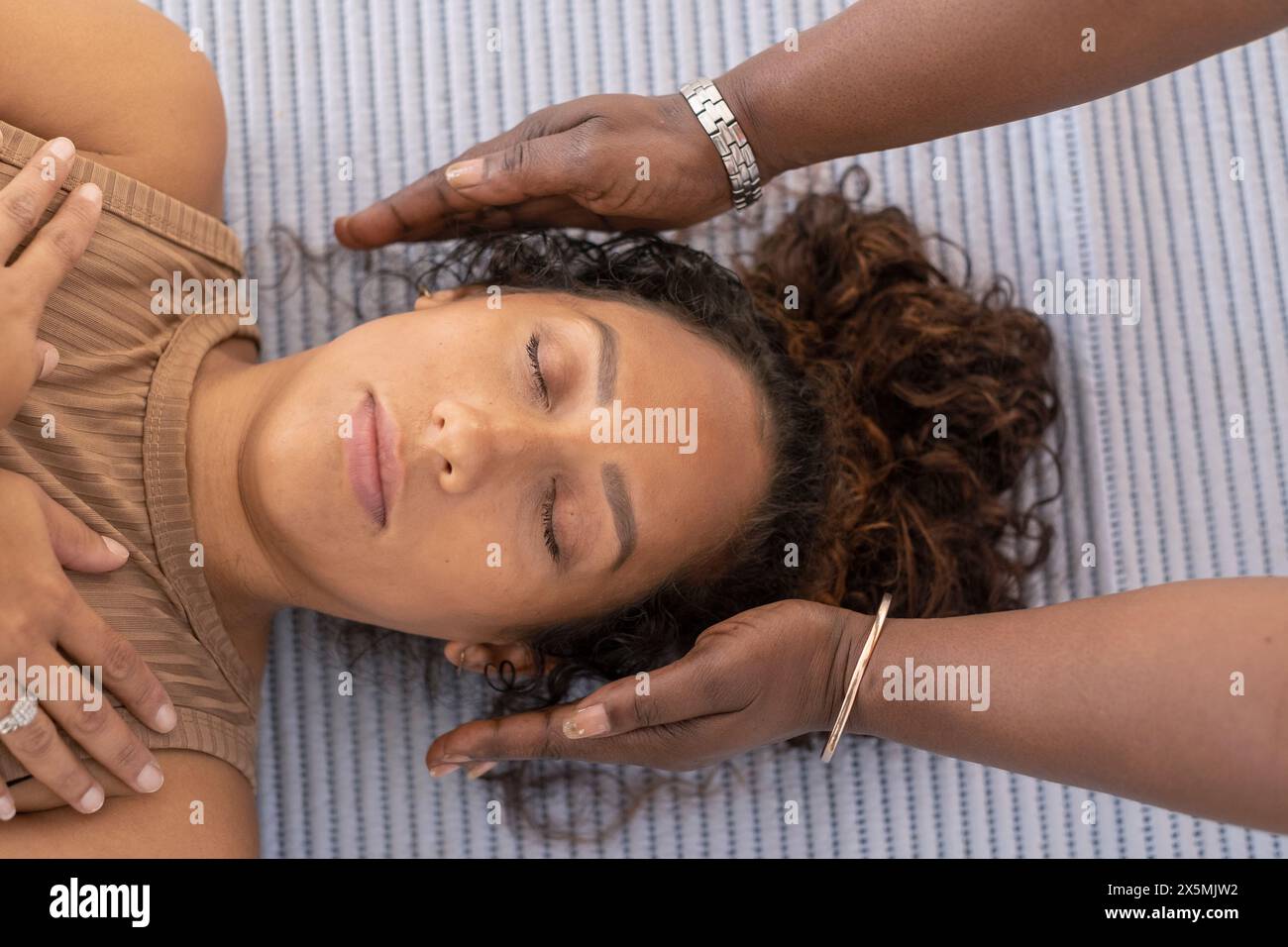 Hände des Yogalehrers auf den Kopf der Frau Stockfoto