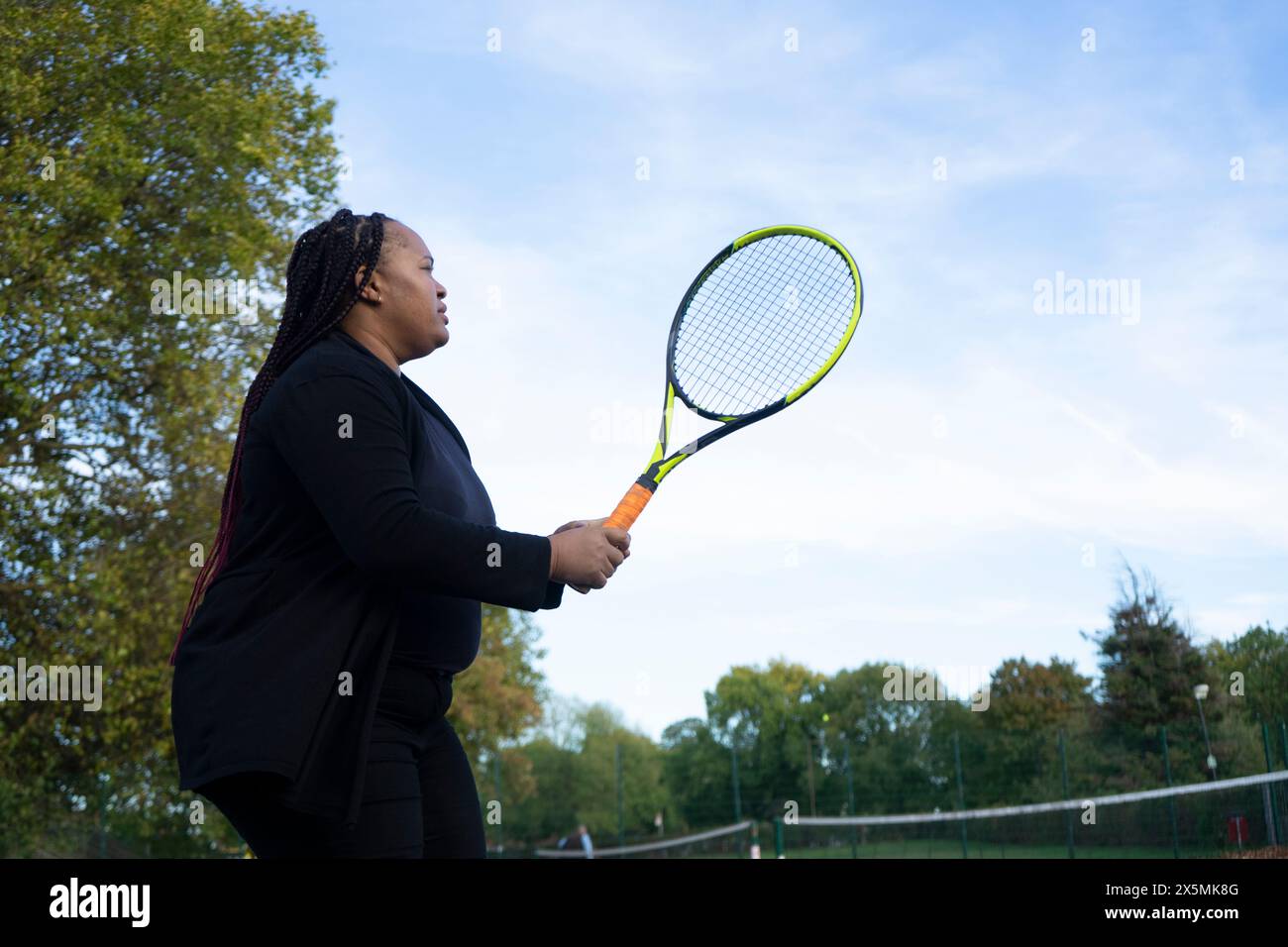 Eine Frau spielt Tennis auf dem Platz in der Nachbarschaft Stockfoto