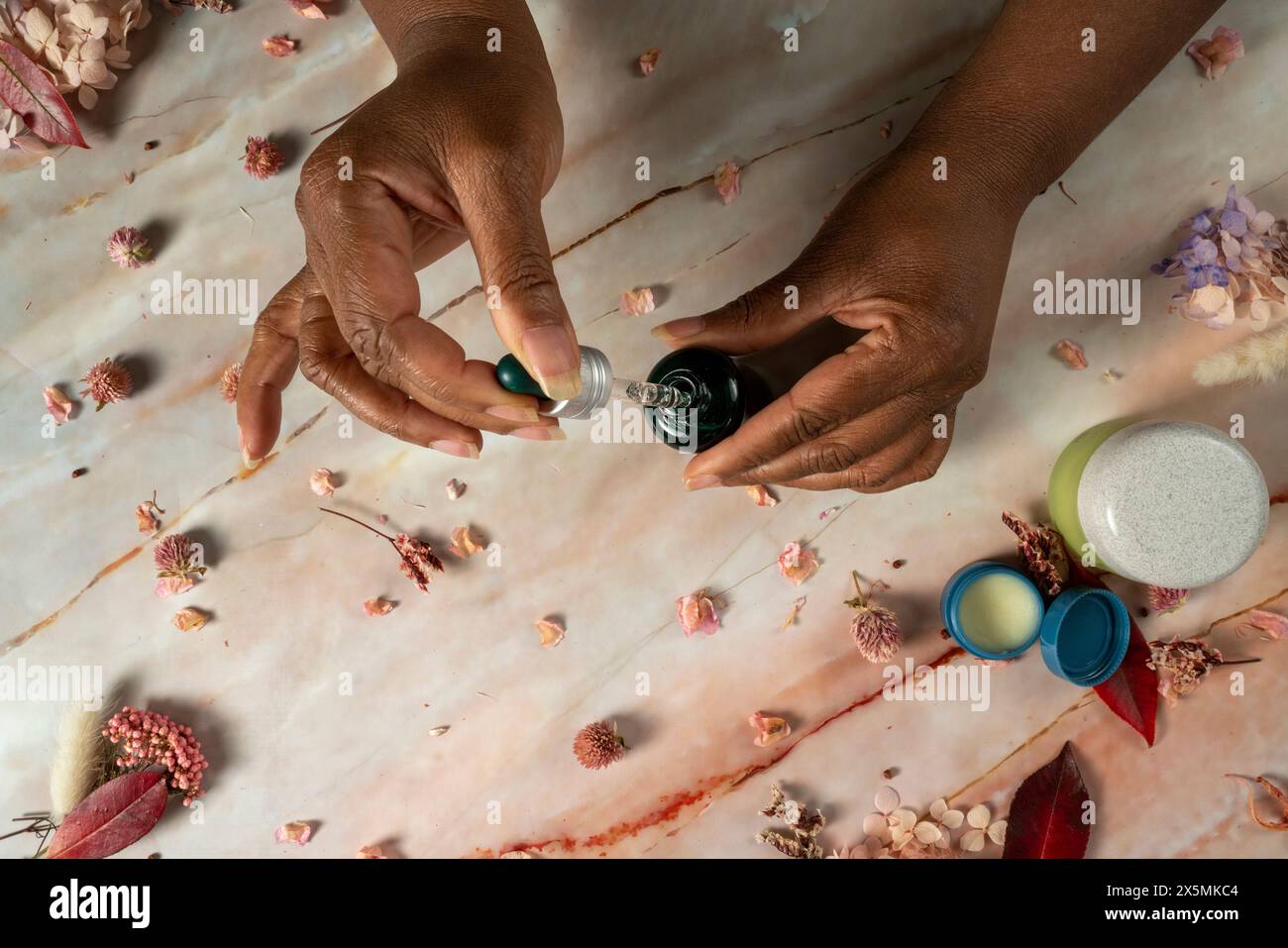 Frau, die Glasflasche mit ätherischem Öl hält Stockfoto