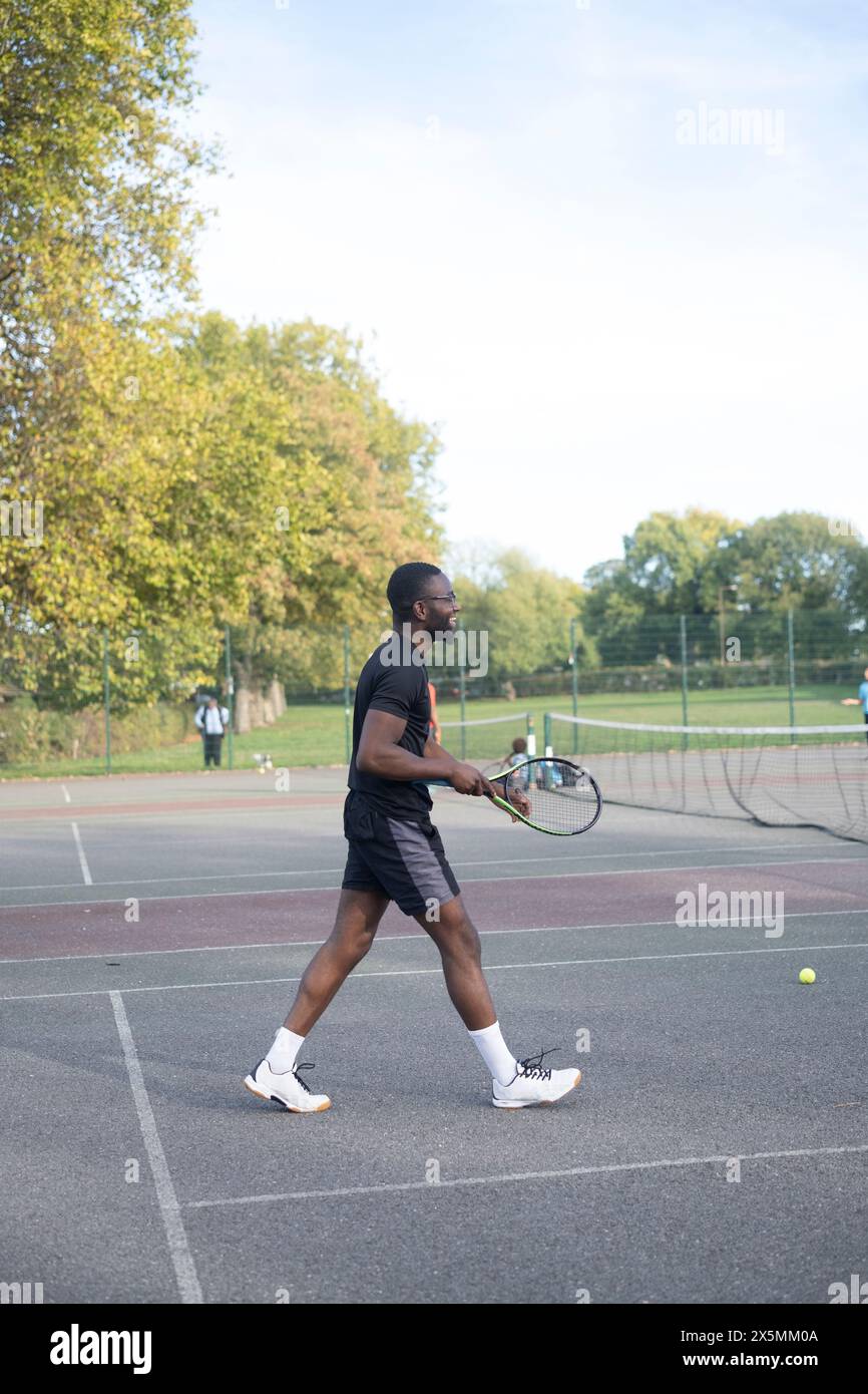 Ein Mann spielt Tennis auf einem Platz in der Nachbarschaft Stockfoto