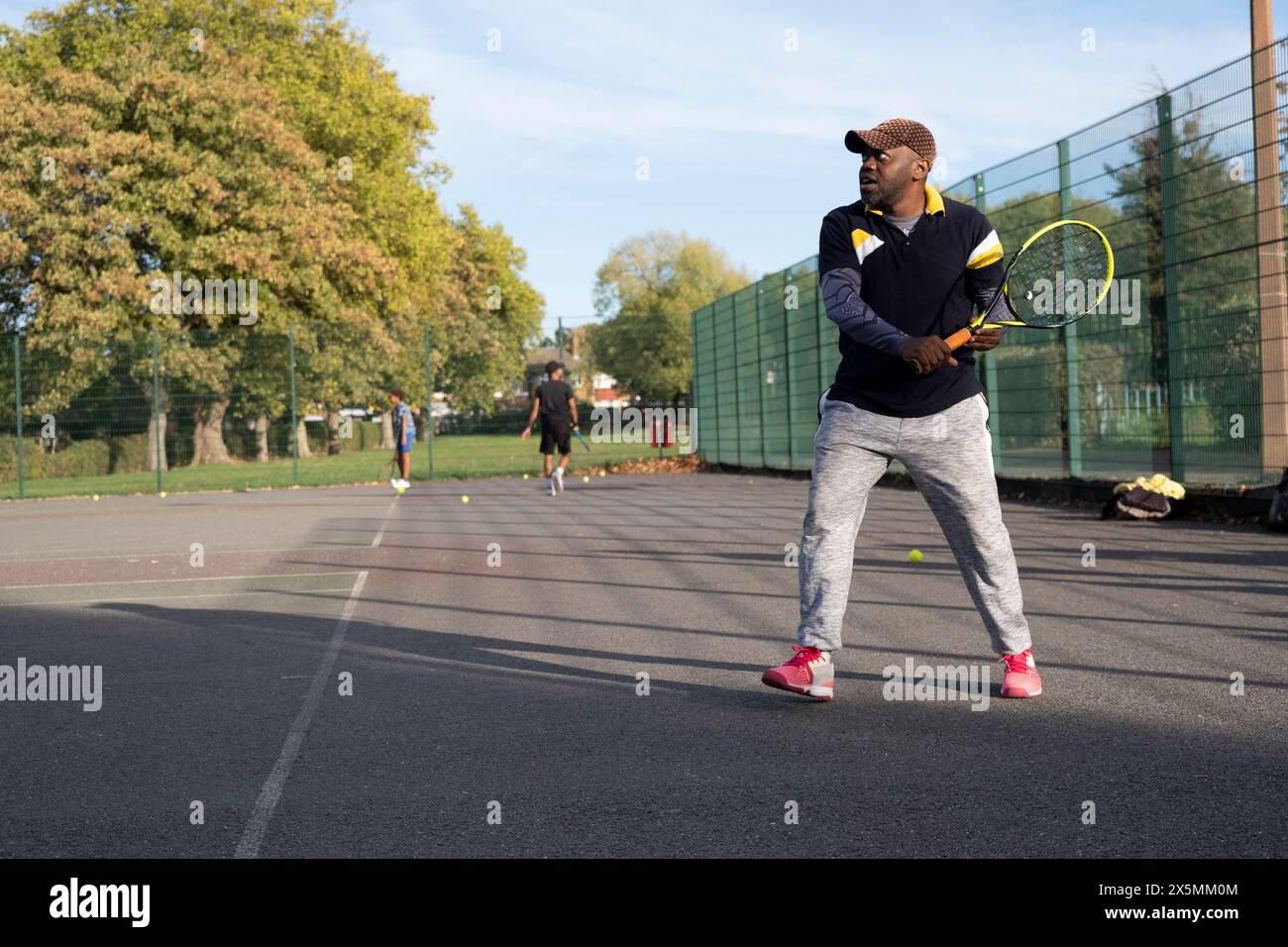 Ein Mann spielt Tennis auf einem Platz in der Nachbarschaft Stockfoto