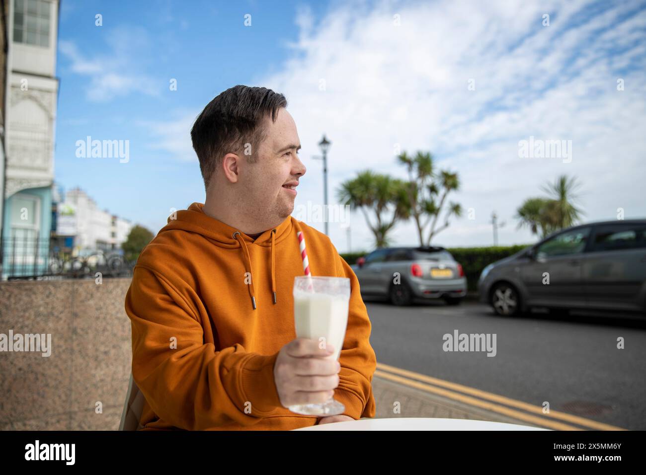 Mann trinkt Milchshake im Straßencafé Stockfoto