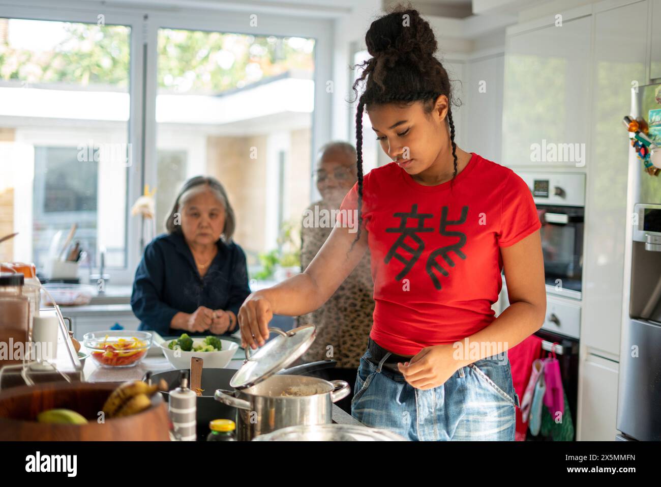 Zwei Frauen und ein Teenager-Mädchen bereiten in der Küche Essen vor Stockfoto