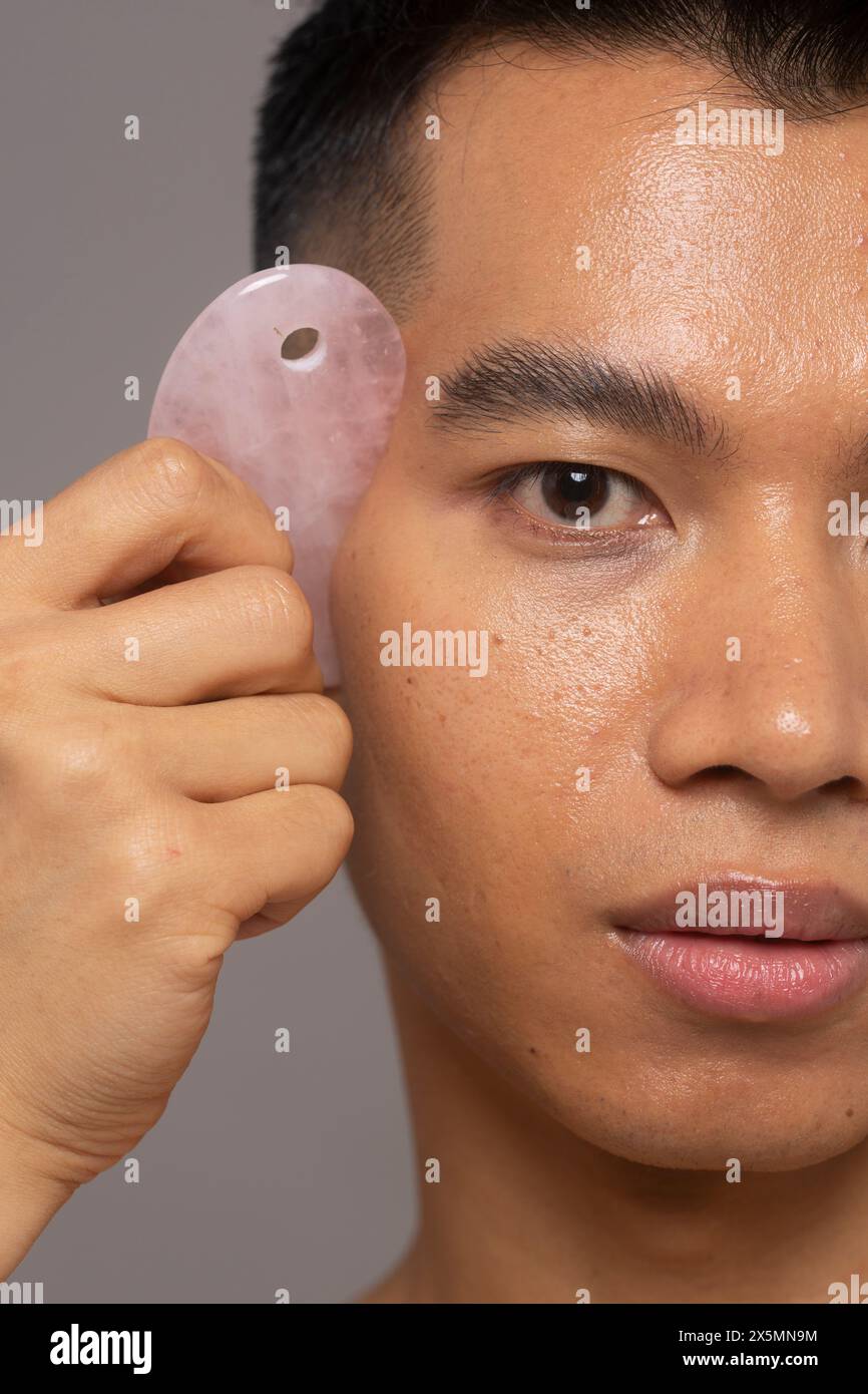 Nahaufnahme einer Person mit Rosenquarz guasha Stockfoto