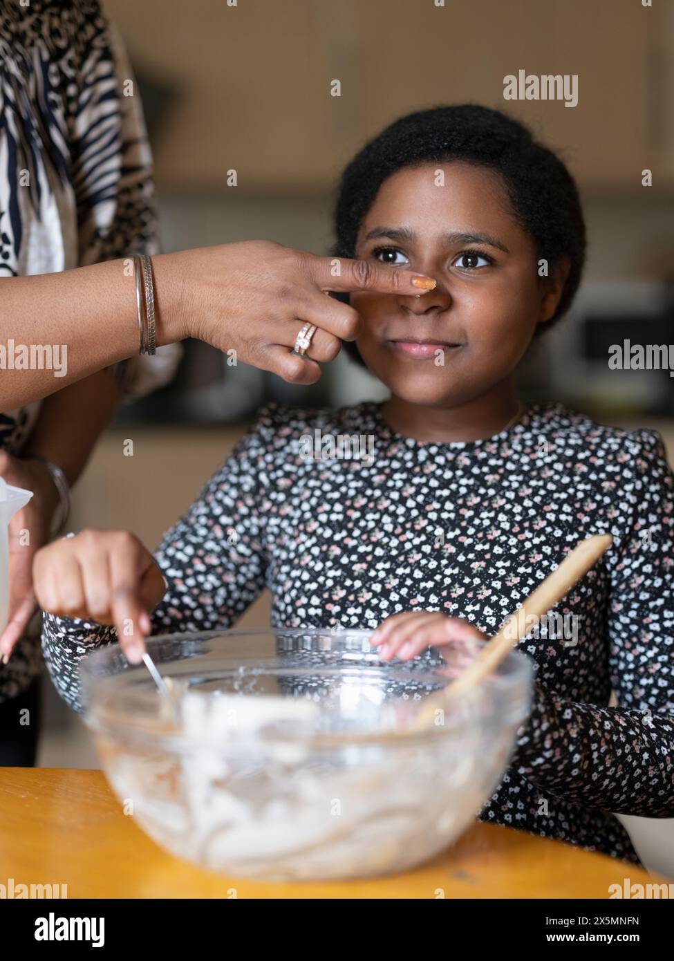 Verspielte Mutter und Tochter backen zu Hause Stockfoto