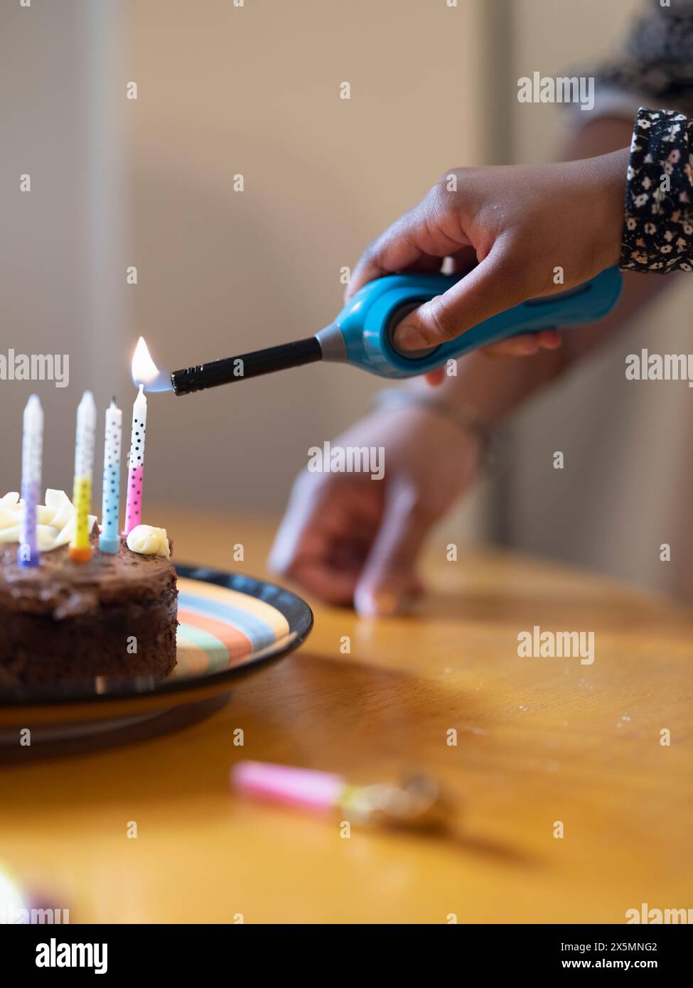 Mädchen Anzünden von Kerzen auf der Geburtstagstorte Stockfoto