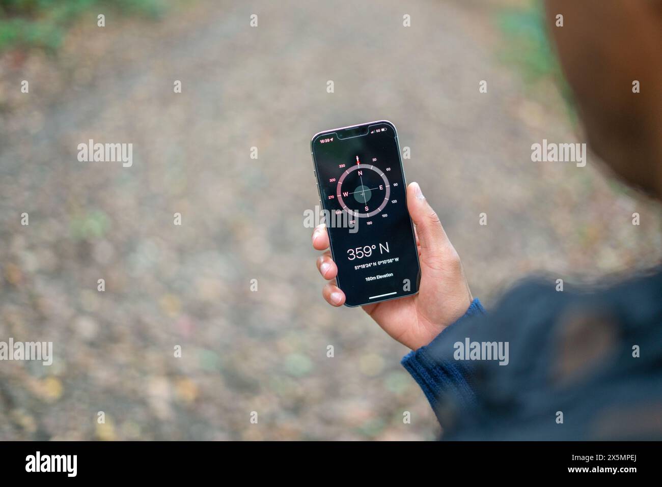 Mann, der während der Wanderung den Kompass auf dem Smartphone benutzt Stockfoto