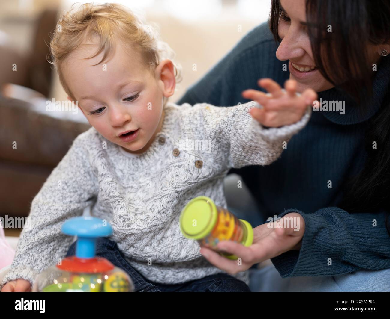 Mutter zeigt dem Sohn Spielzeug Stockfoto