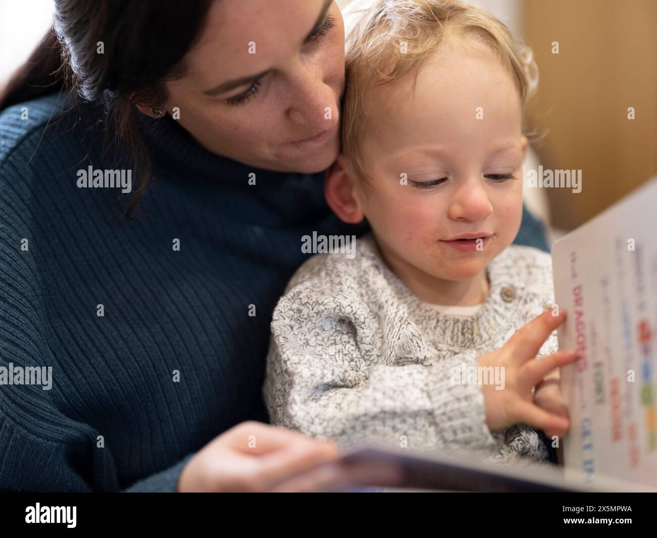 Sohn liest Buch mit Mutter Stockfoto