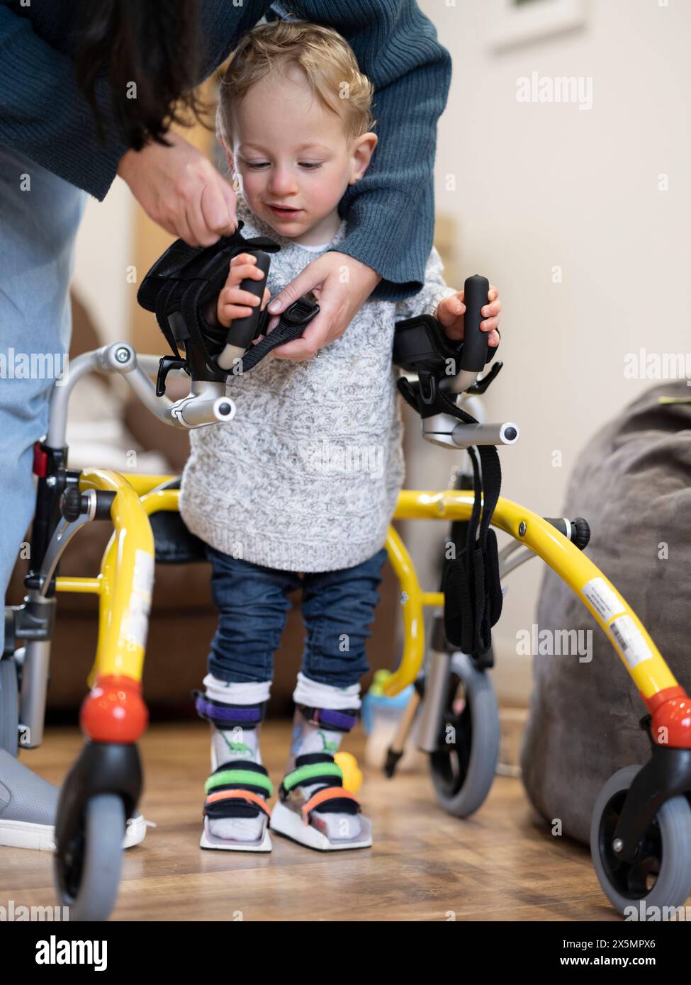 Mutter, die Sohn mit Zerebralparese beim Gehen unterstützt Stockfoto