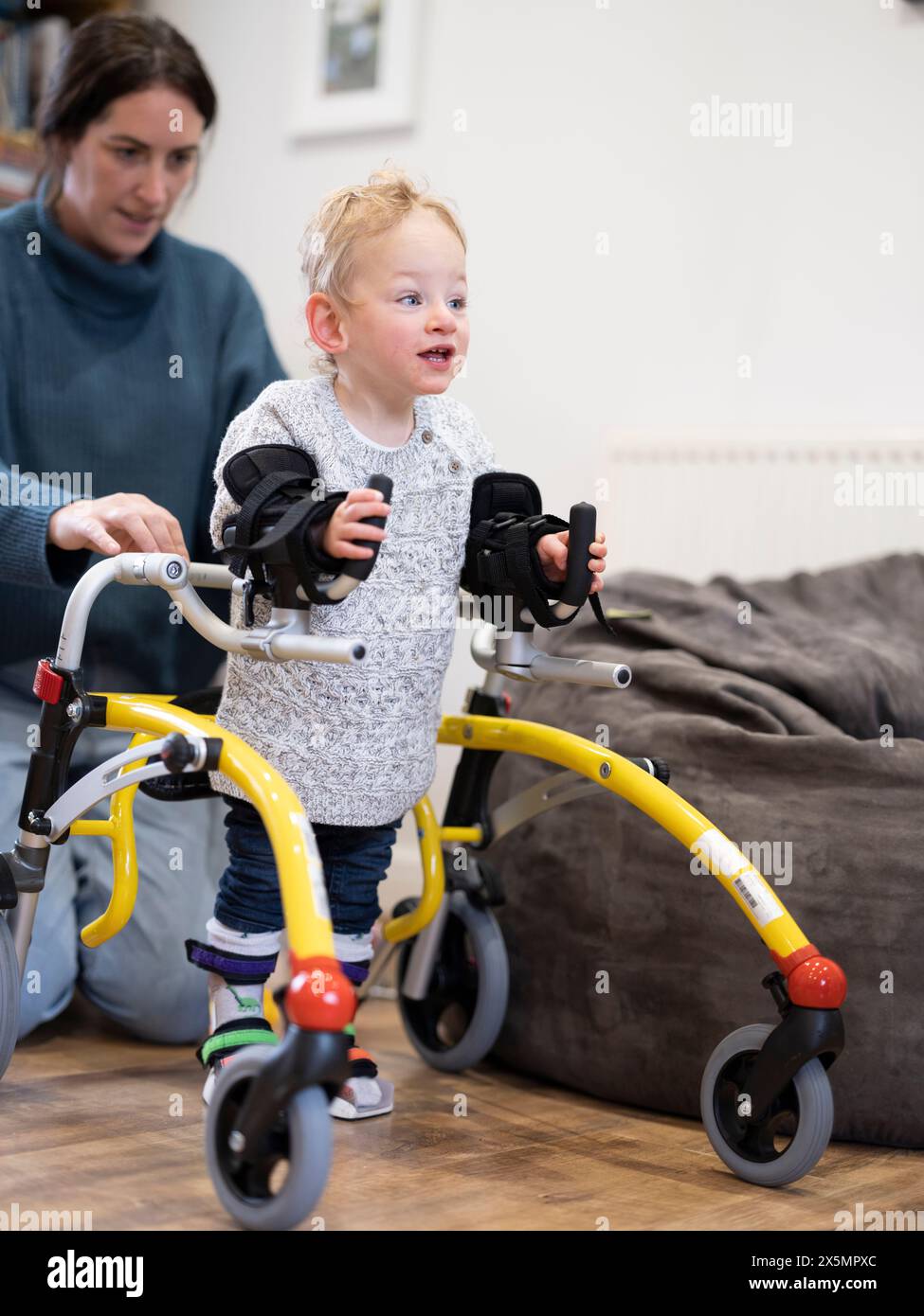 Mutter, die Sohn mit Zerebralparese beim Gehen unterstützt Stockfoto