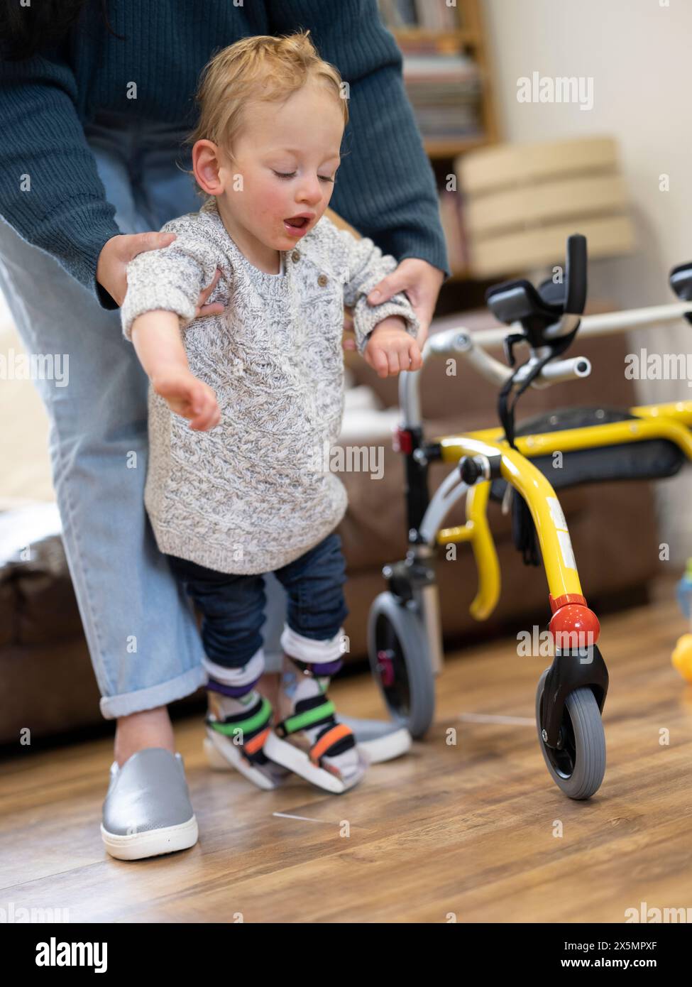 Mutter, die Sohn mit Zerebralparese beim Gehen unterstützt Stockfoto