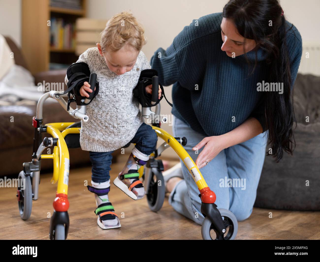 Mutter, die Sohn mit Zerebralparese assistiert Stockfoto