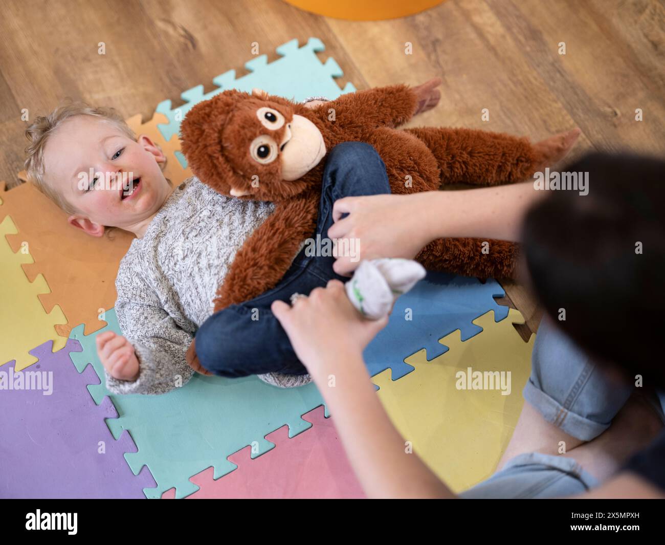 Der hohe Winkel der Mutter, die dem Sohn bei Übungen hilft Stockfoto