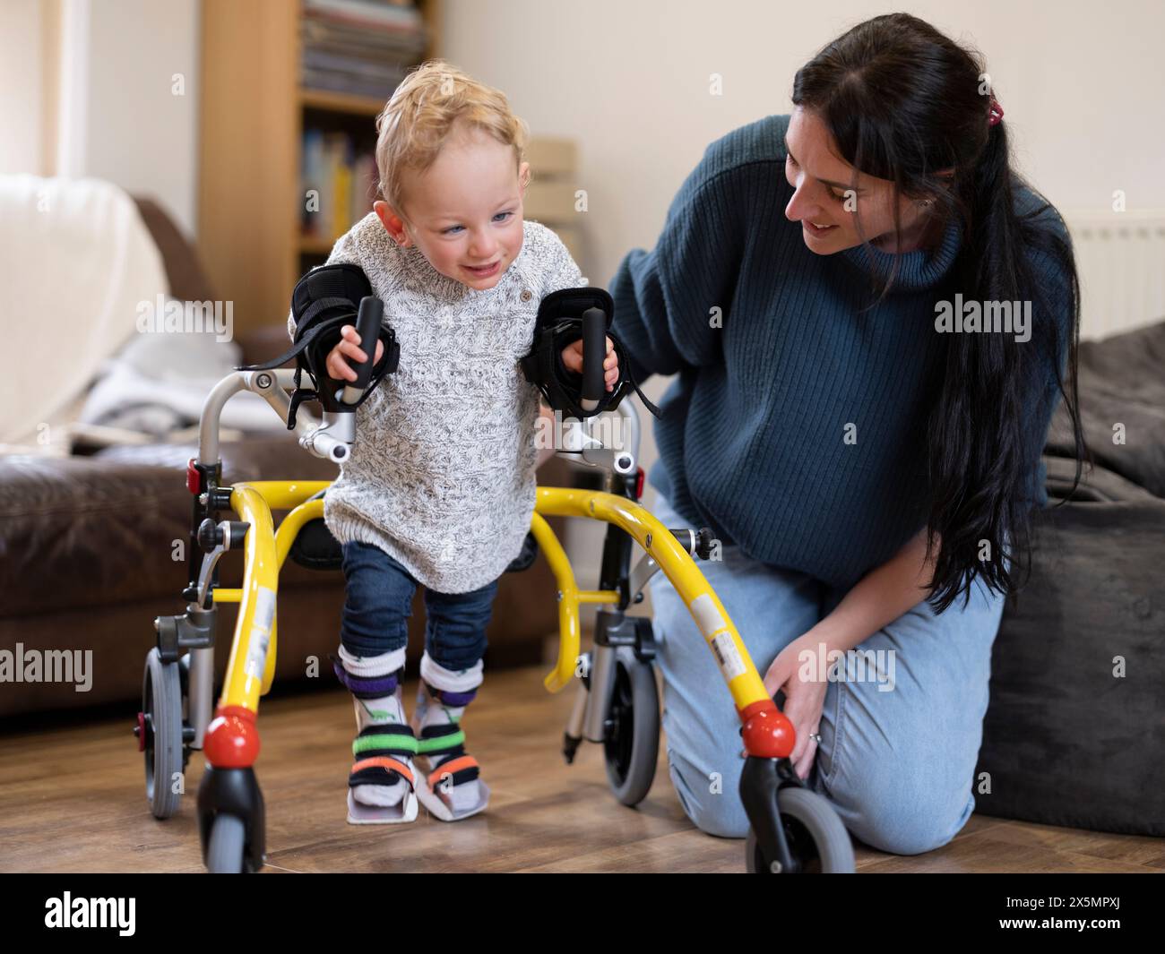 Mutter hilft dem Sohn beim Gehen Stockfoto