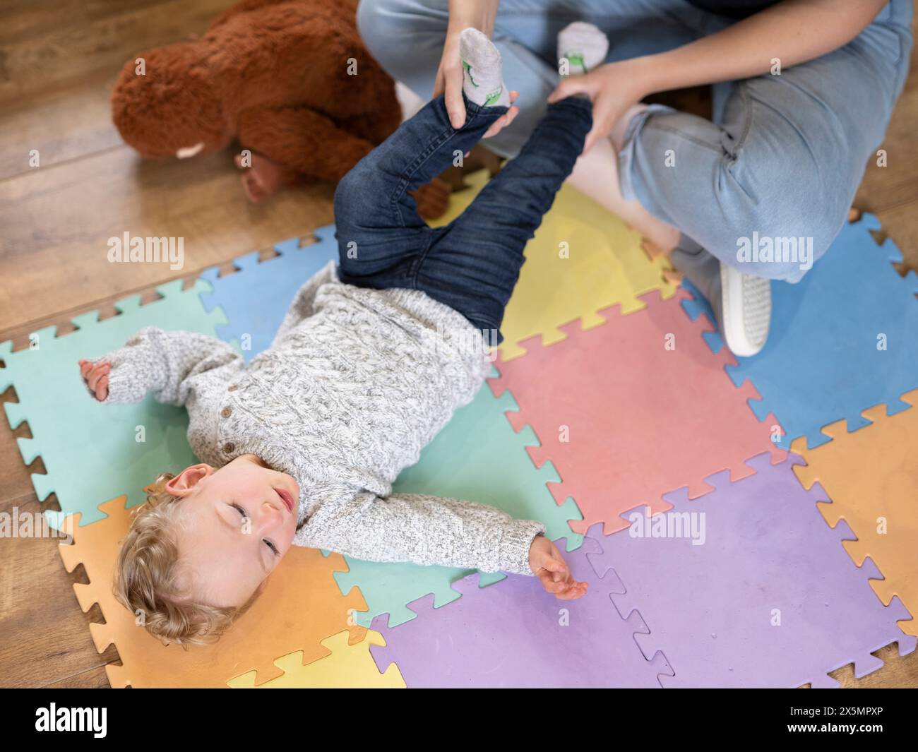 Der hohe Winkel der Mutter, die dem Sohn bei Übungen hilft Stockfoto