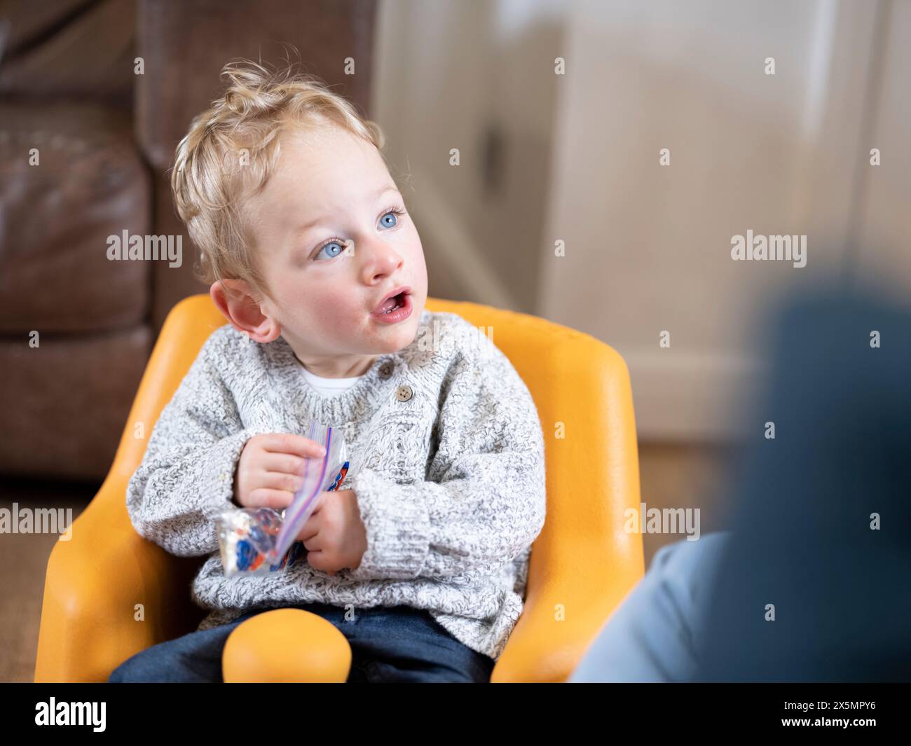 Blonder Junge in Babyschale mit Plastiktüte Stockfoto