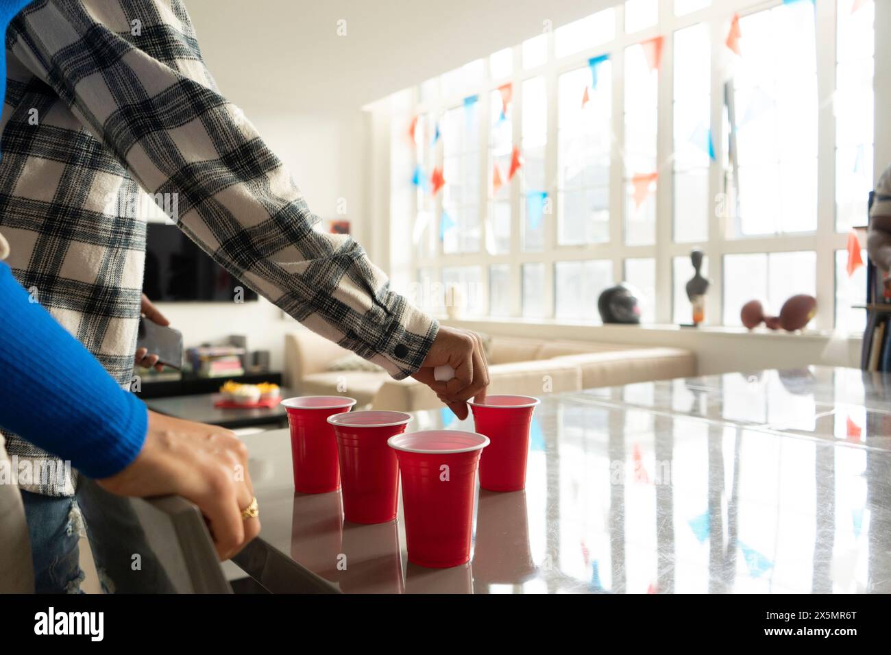 Nahaufnahme von Freunden, die Bier-Pong auf dem Tisch auf der Heimparty spielen Stockfoto