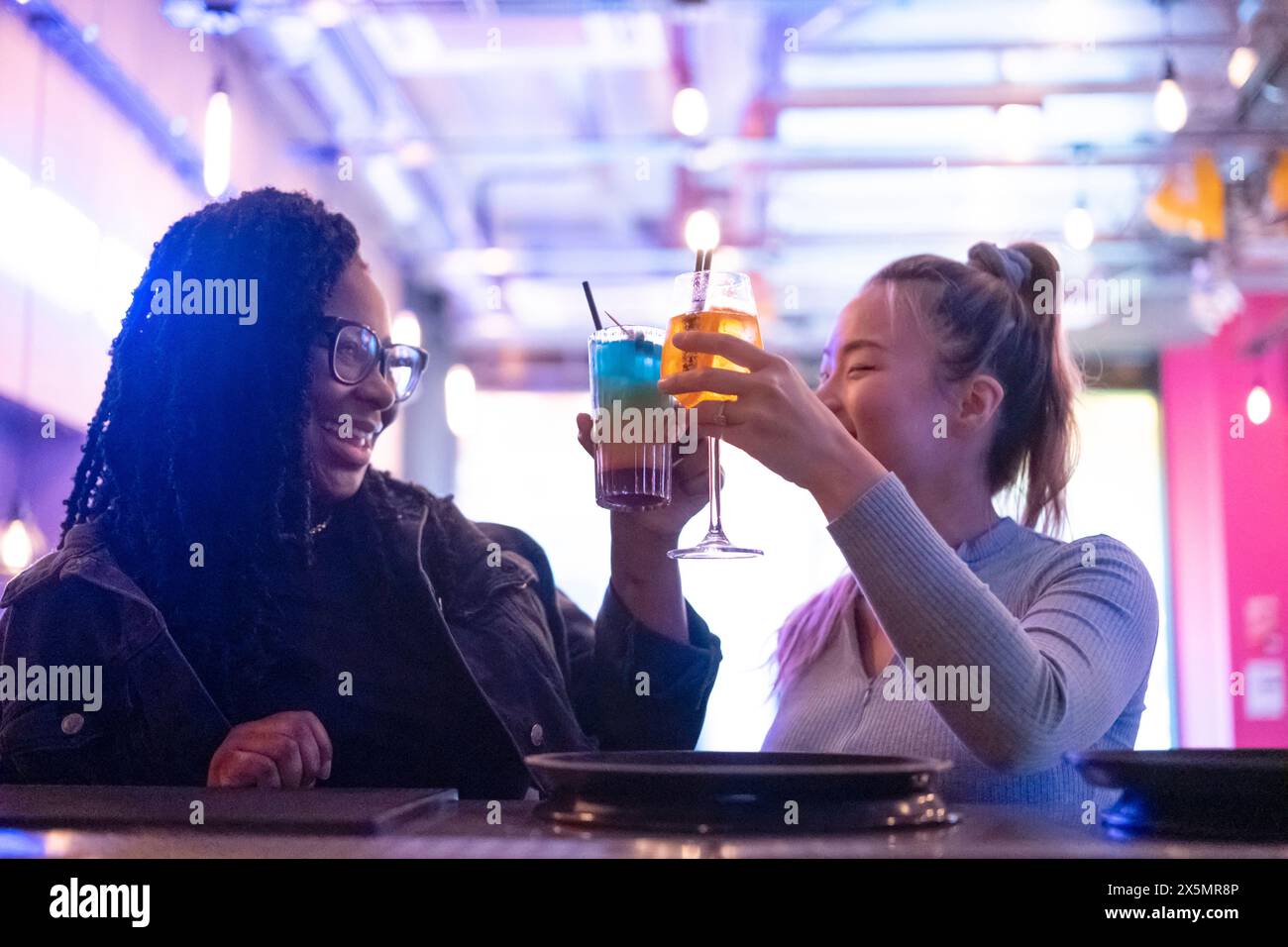 Weibliche Freunde trinken Cocktails an der Bar Stockfoto
