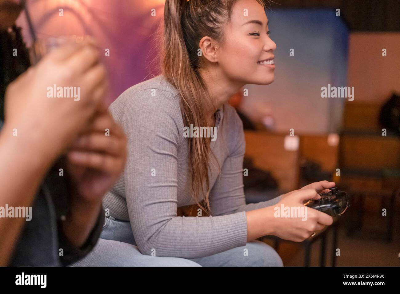 Freunde spielen in Videospielen im Pub Stockfoto