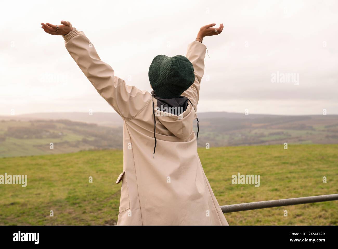 Junge Wanderer in der Landschaft mit erhobenen Armen Stockfoto
