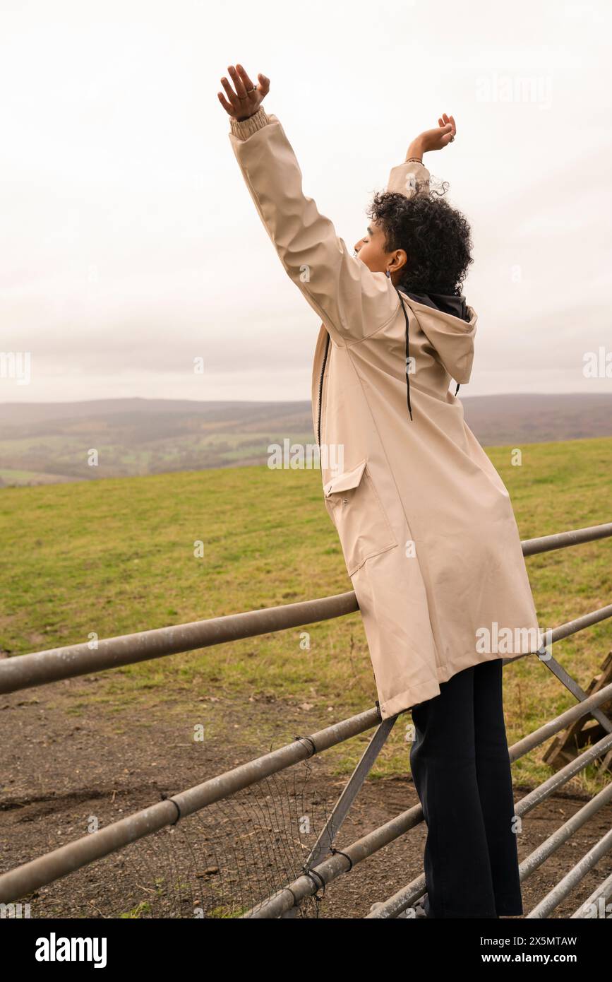Junge Wanderer in der Landschaft mit erhobenen Armen Stockfoto