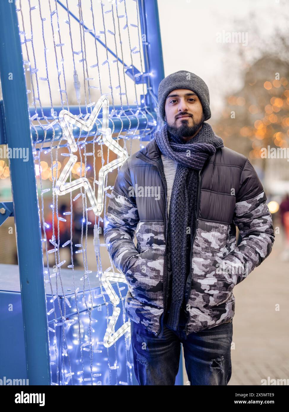 Porträt eines jungen Mannes, der neben Weihnachtsdekorationen steht Stockfoto