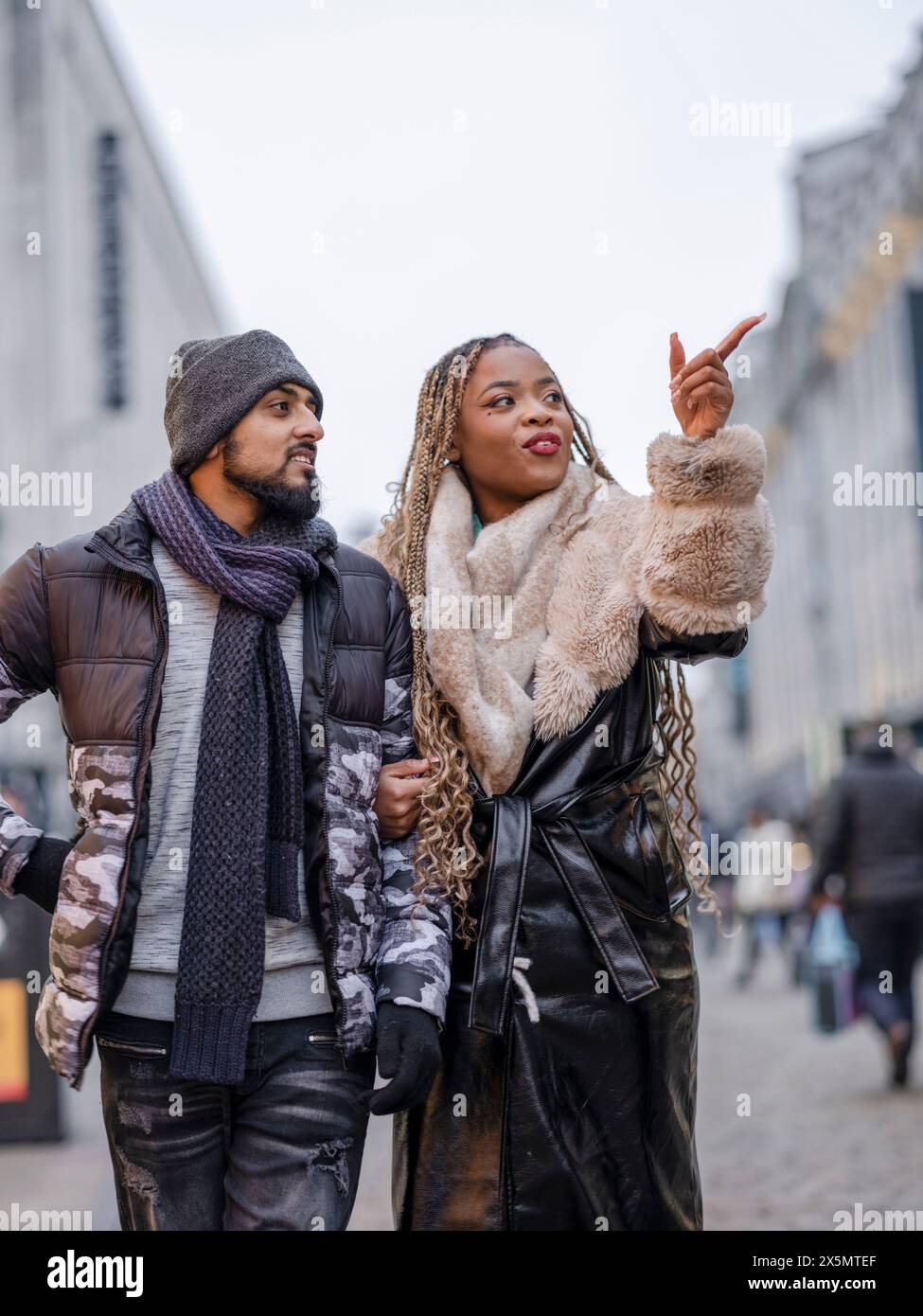 Lächelndes junges Paar, das in der Stadt herumläuft Stockfoto