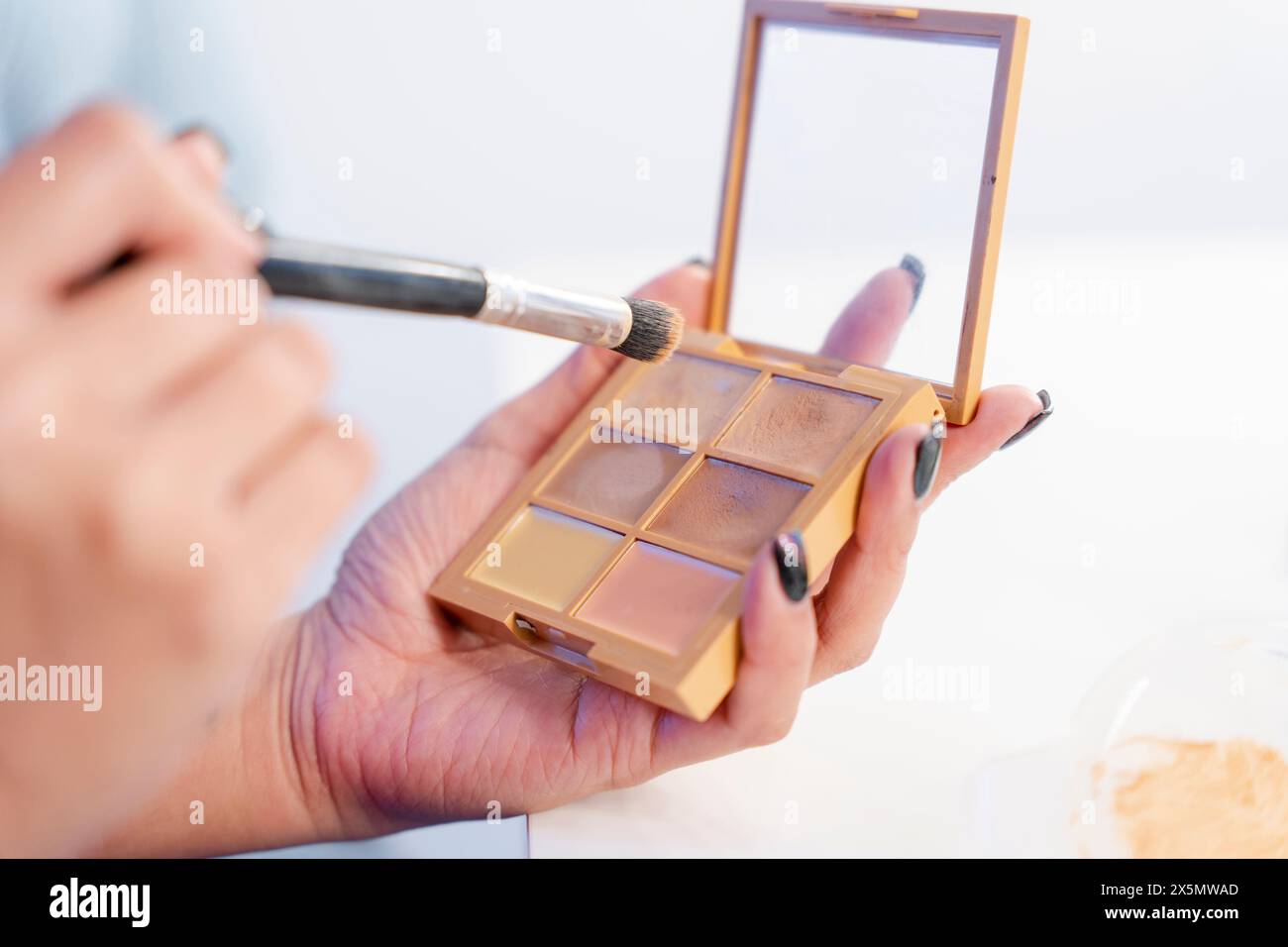 Nahaufnahme der Hand, die Augenschatten hält Stockfoto