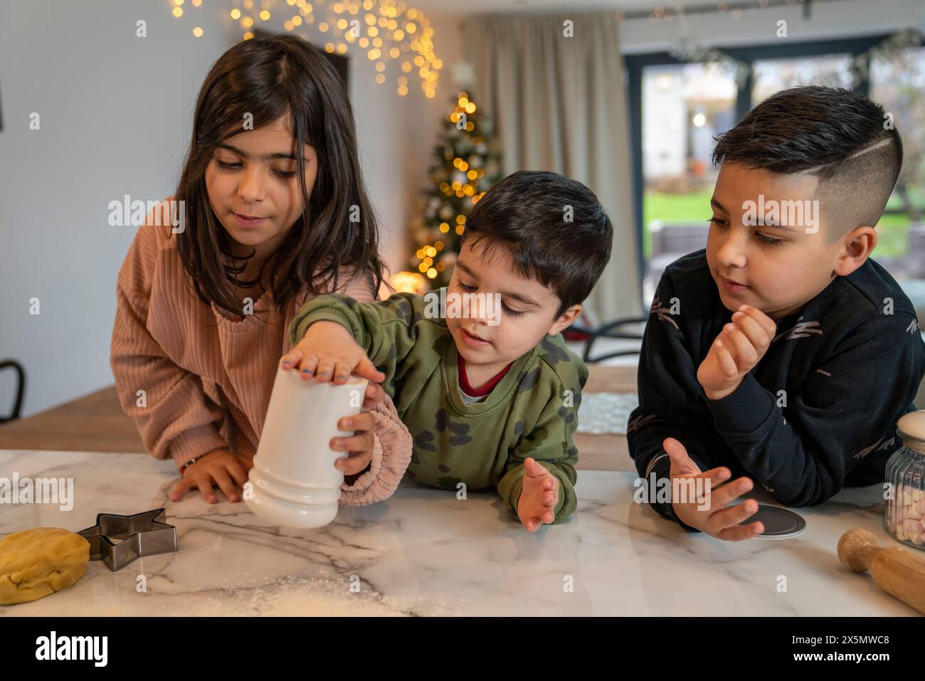 Kinder bereiten Weihnachtskekse in der Küche vor Stockfoto