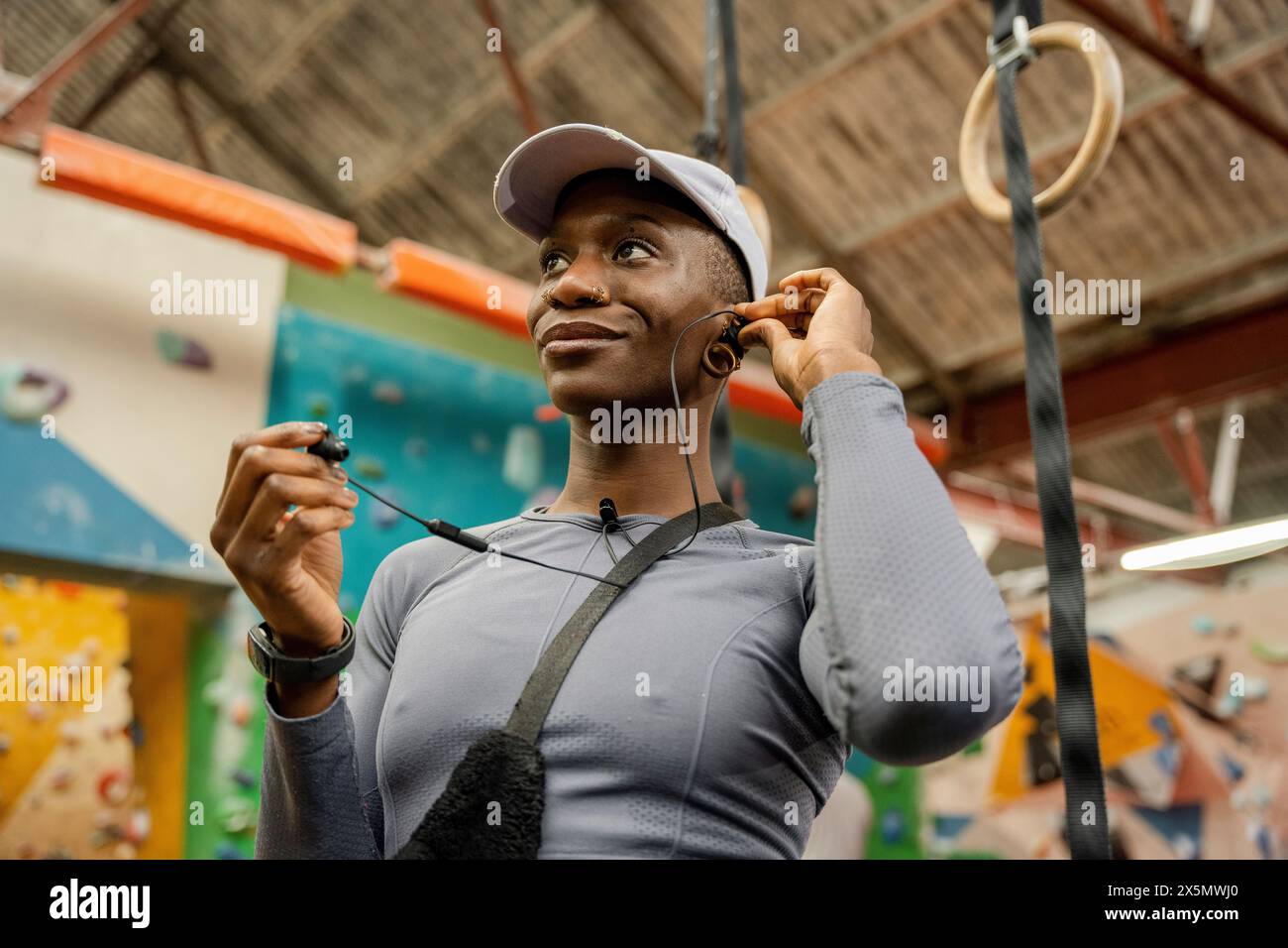 Frau, die im Fitnessstudio Kopfhörer aufsetzt Stockfoto