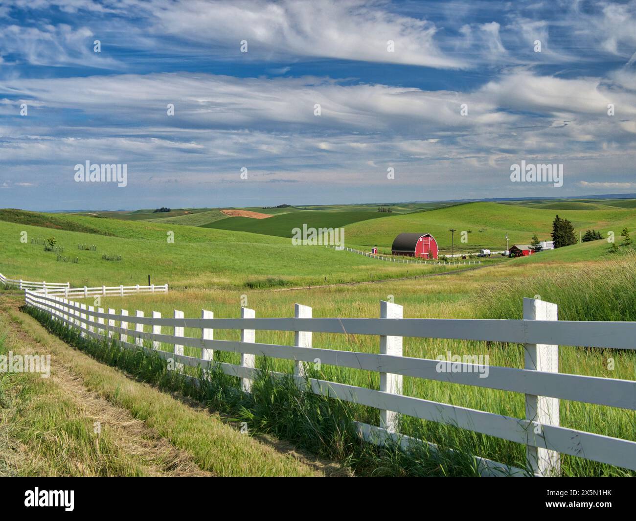 USA, Idaho, Palouse. Weiße Zaunlinie, die zu einer Landfarm führt. (Nur Für Redaktionelle Zwecke) Stockfoto
