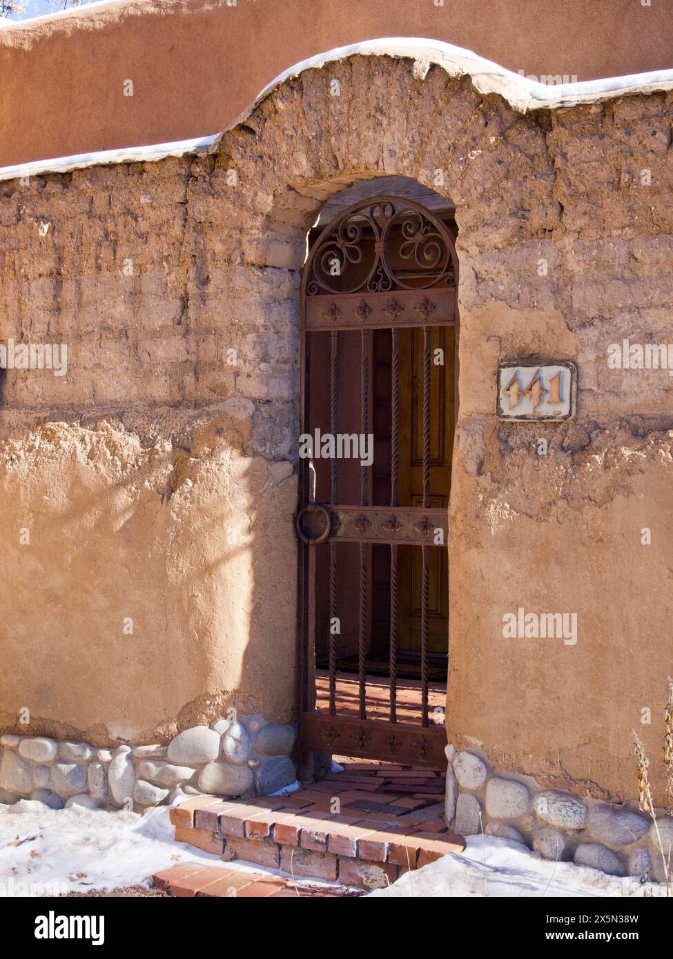 USA, New Mexico, Sante Fe. Schmiedeeisernes Tor am Eingang zu einem Haus aus lehmziegel. (Nur Für Redaktionelle Zwecke) Stockfoto