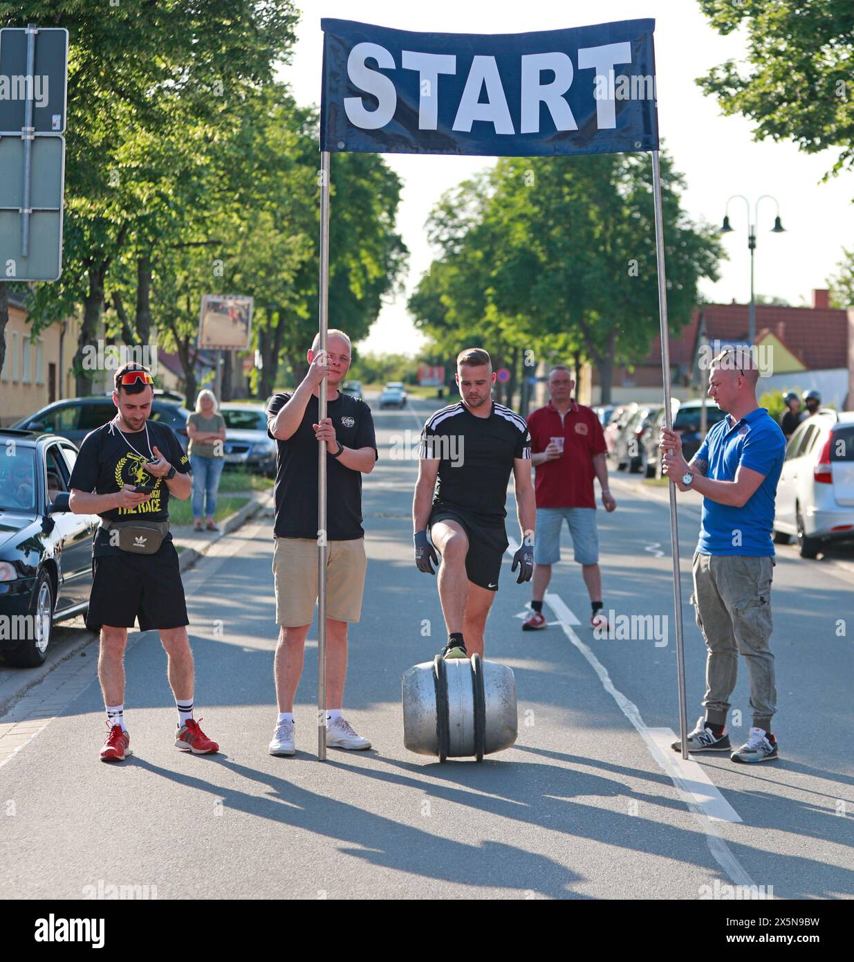 Ballenstedt, Deutschland. Mai 2024. Frank Kranich rollt sein Fass zum Ausgangspunkt in Hoym. Die traditionelle Fassrolle von Hoym nach Badeborn wurde wieder in der kleinen Stadt abgehalten. Ein Teilnehmer aus Badeborn muss mit einem Fass eine Distanz von fast 6 Kilometern zurücklegen. Der Fass ist mit Wasser gefüllt und wiegt 60 kg. Frank Kranich entschied sich, dieses Jahr teilzunehmen. Er trainierte acht Wochen lang. Der 39. Lauf-Roll stammt von einer Wette aus dem Jahr 1984, als er zum ersten Mal ein Fass von Hoym nach Badeborn rollte. Quelle: Matthias Bein/dpa/Alamy Live News Stockfoto